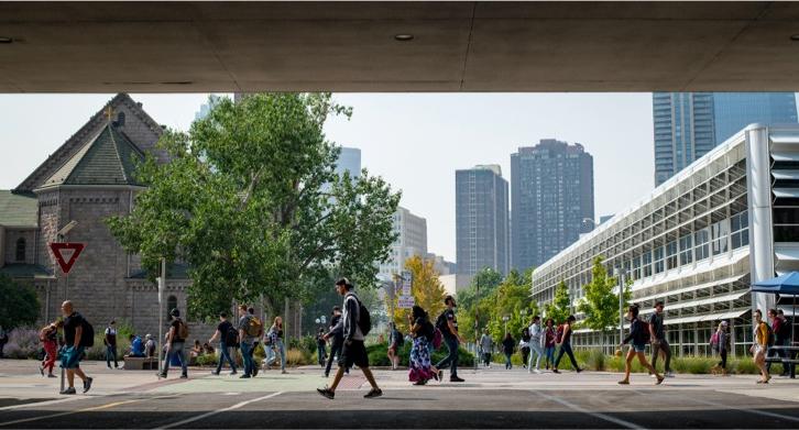 Students walking on campus next to the library