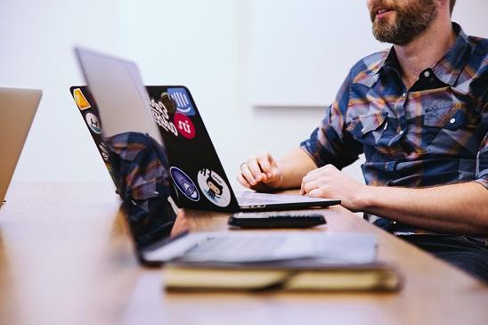 A young man sitting at a desk using a laptop