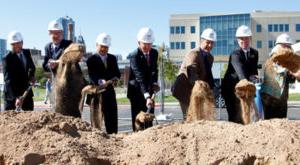 Men in suits shoveling dirt