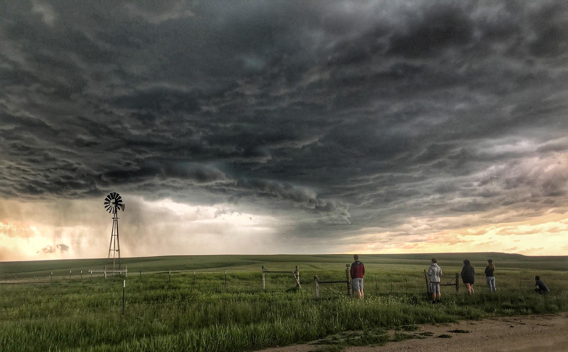 A photo of a severe thunderstorm with students observing it