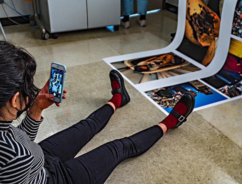 Student taking photograph of images