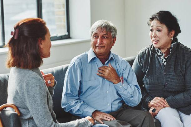 Three people sitting on couch speaking to each other