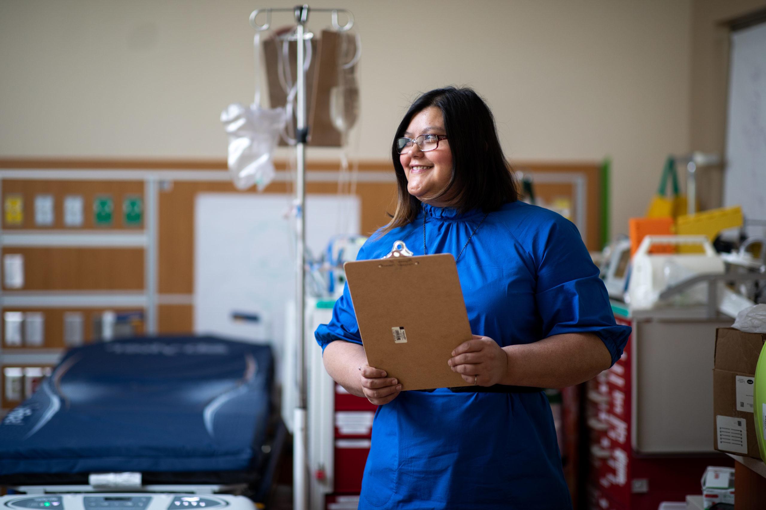 Person standing in medical office with clipboard