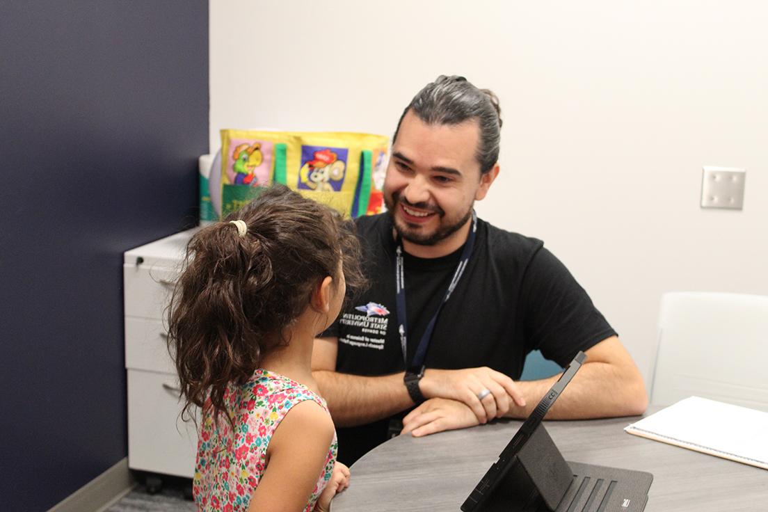 Graduate MS SLP student (left) working with elementary school aged child (right)