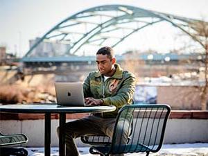 Student on a laptop, outside in Downtown Denver.