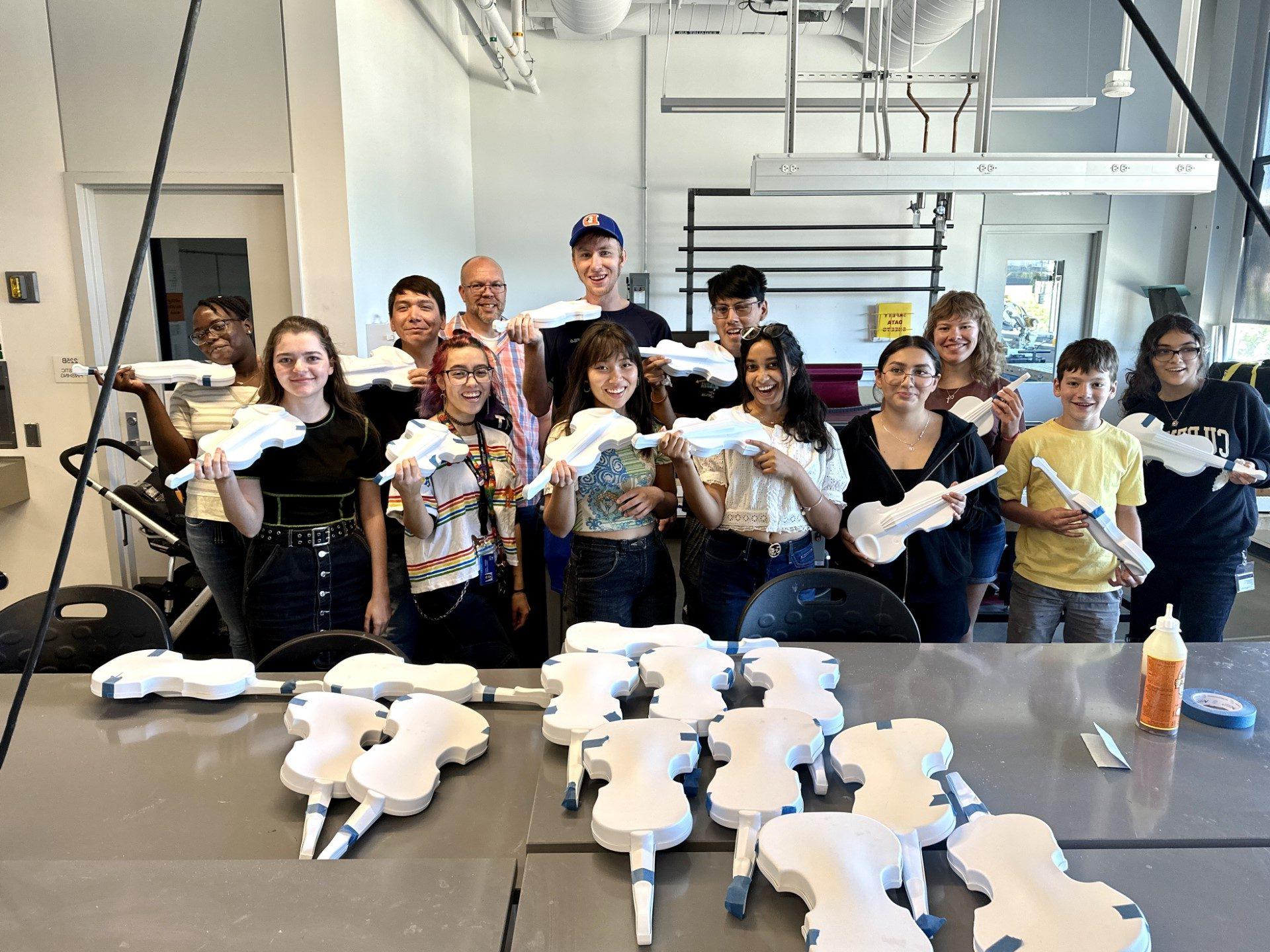 Students holding 3D printed violins they helped make