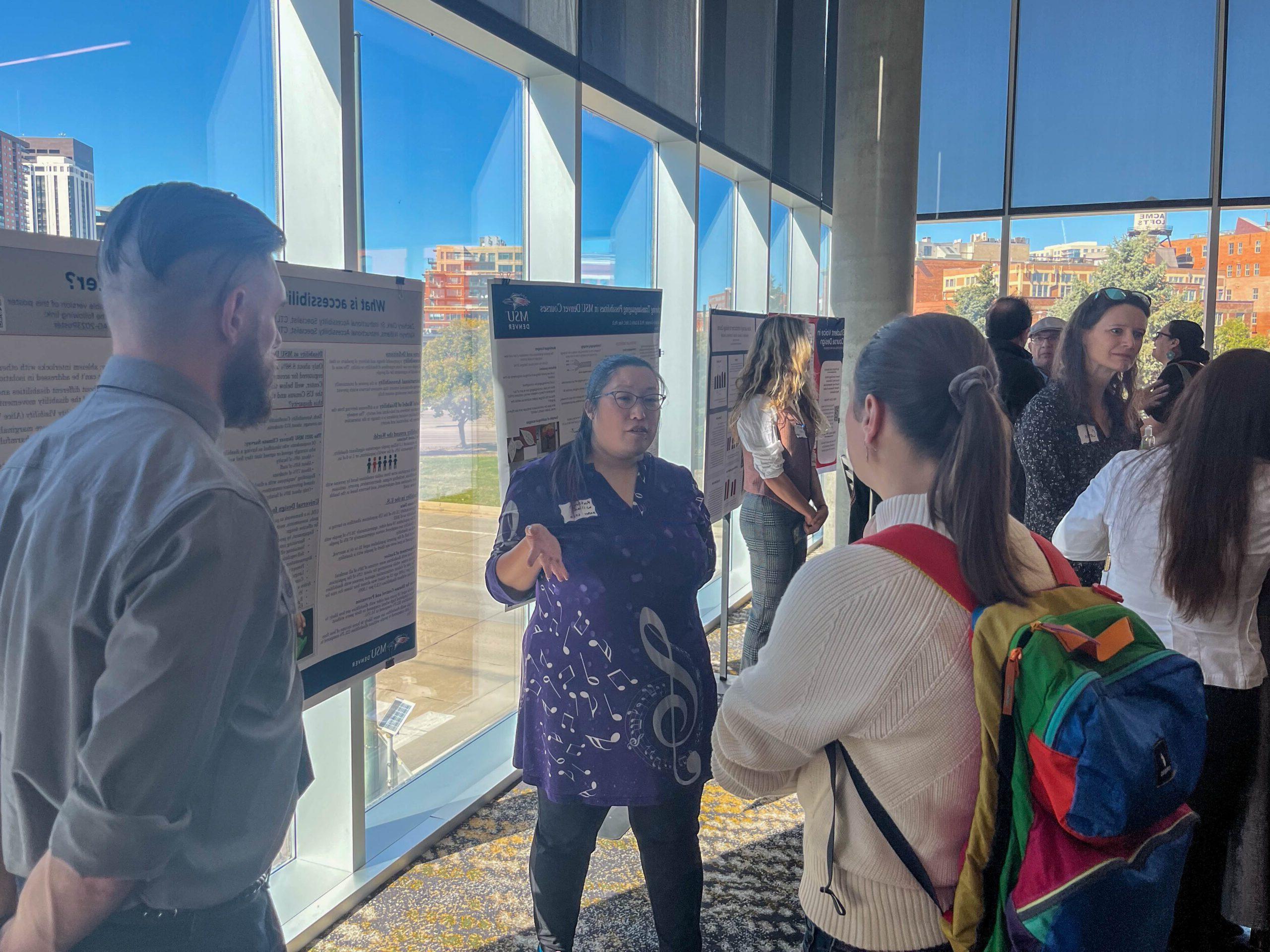 Faculty and staff discussing research projects at the SoTL poster session