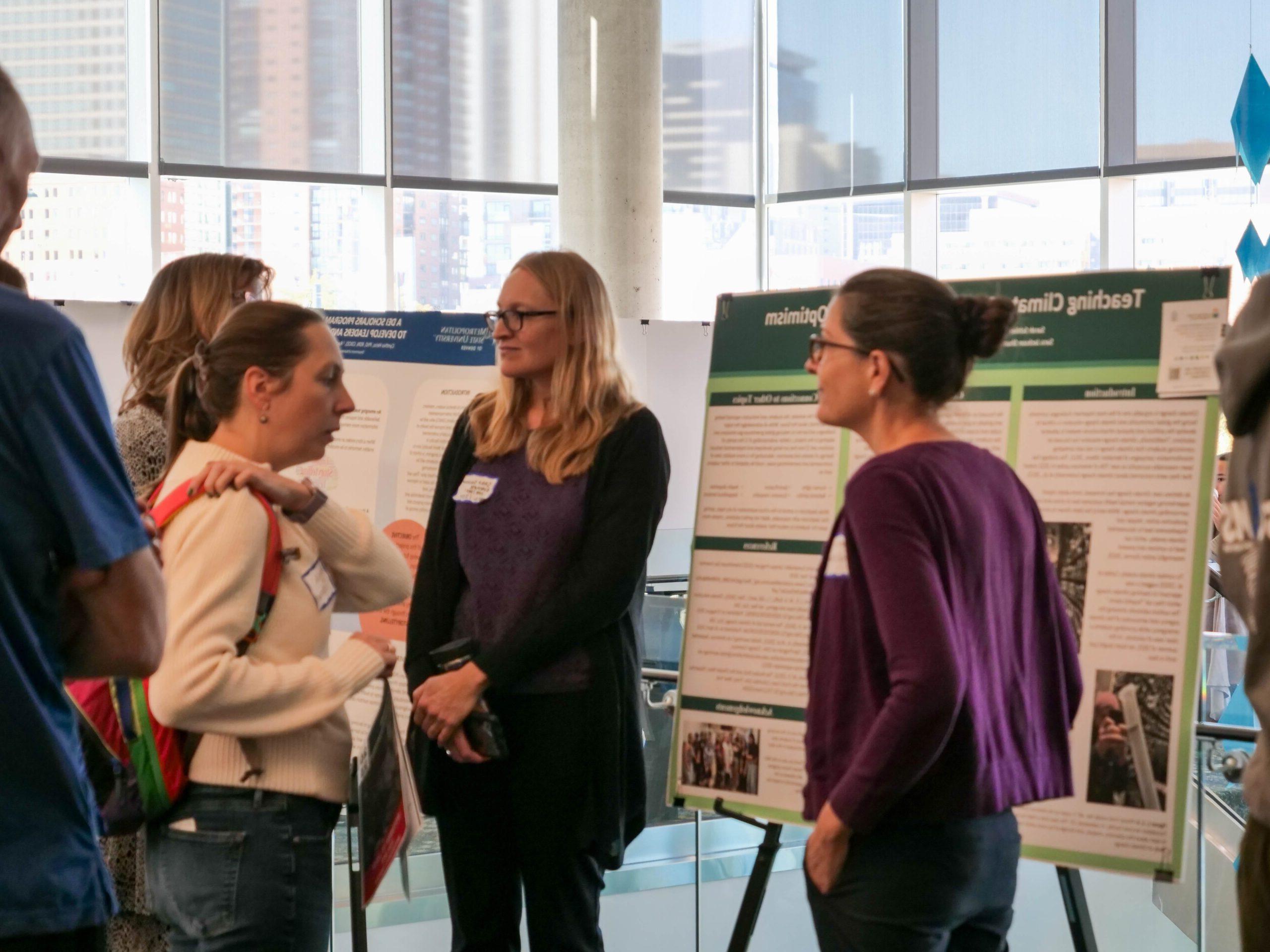 Faculty and staff discussing research projects at the SoTL poster session