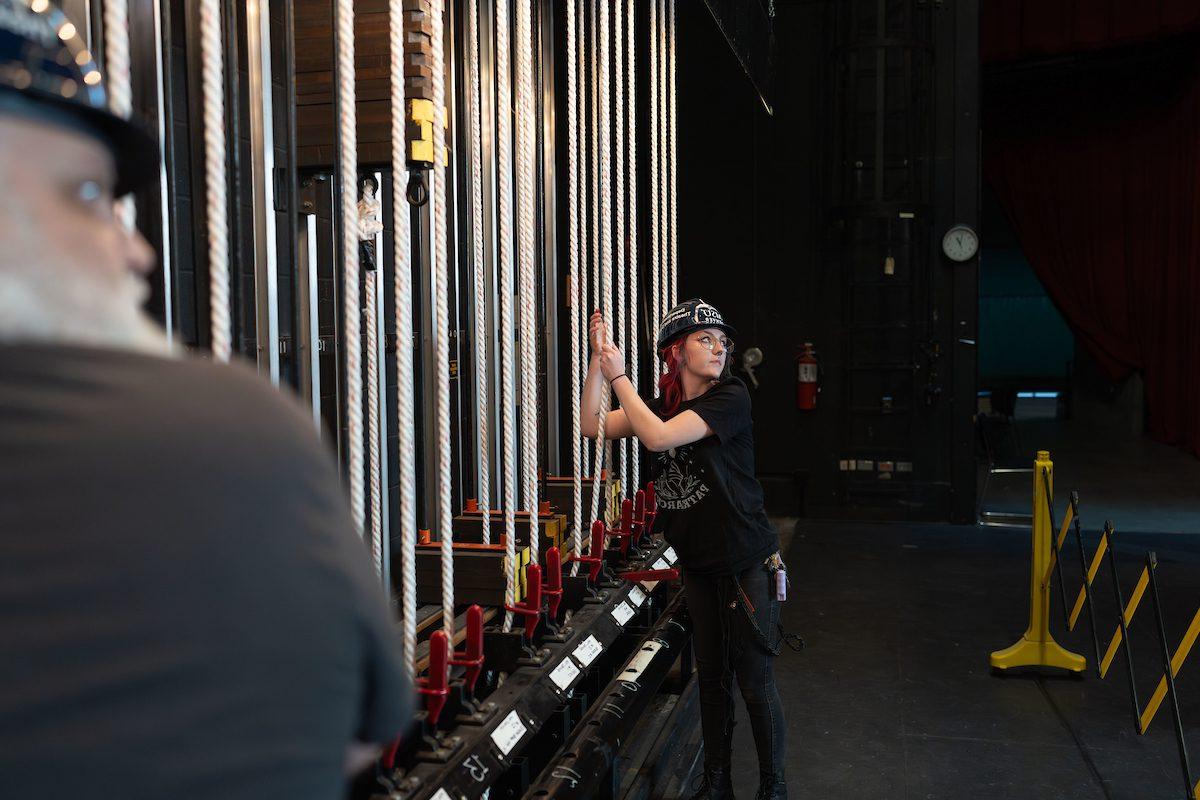 Zee Leona Howard and other work-study students hanging lights for an upcoming show, Footloose.