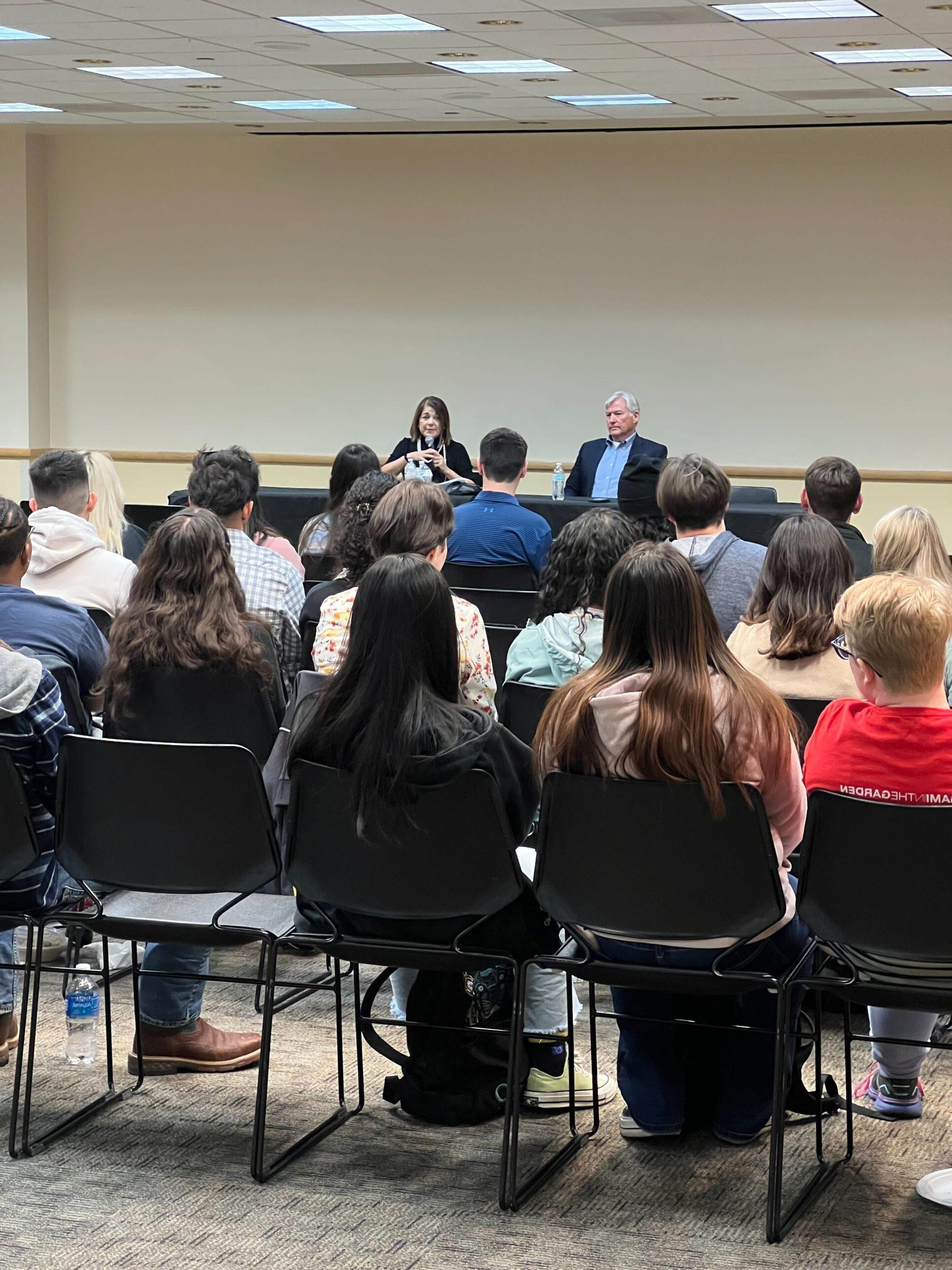 2 former congress members speaking to a room full of students