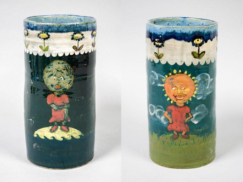 Wheel thrown cylinder image includes front with decorated images of a sun character on one, and moon character on the other. The one with the sun contains bright colors, and the moon with dark colors.