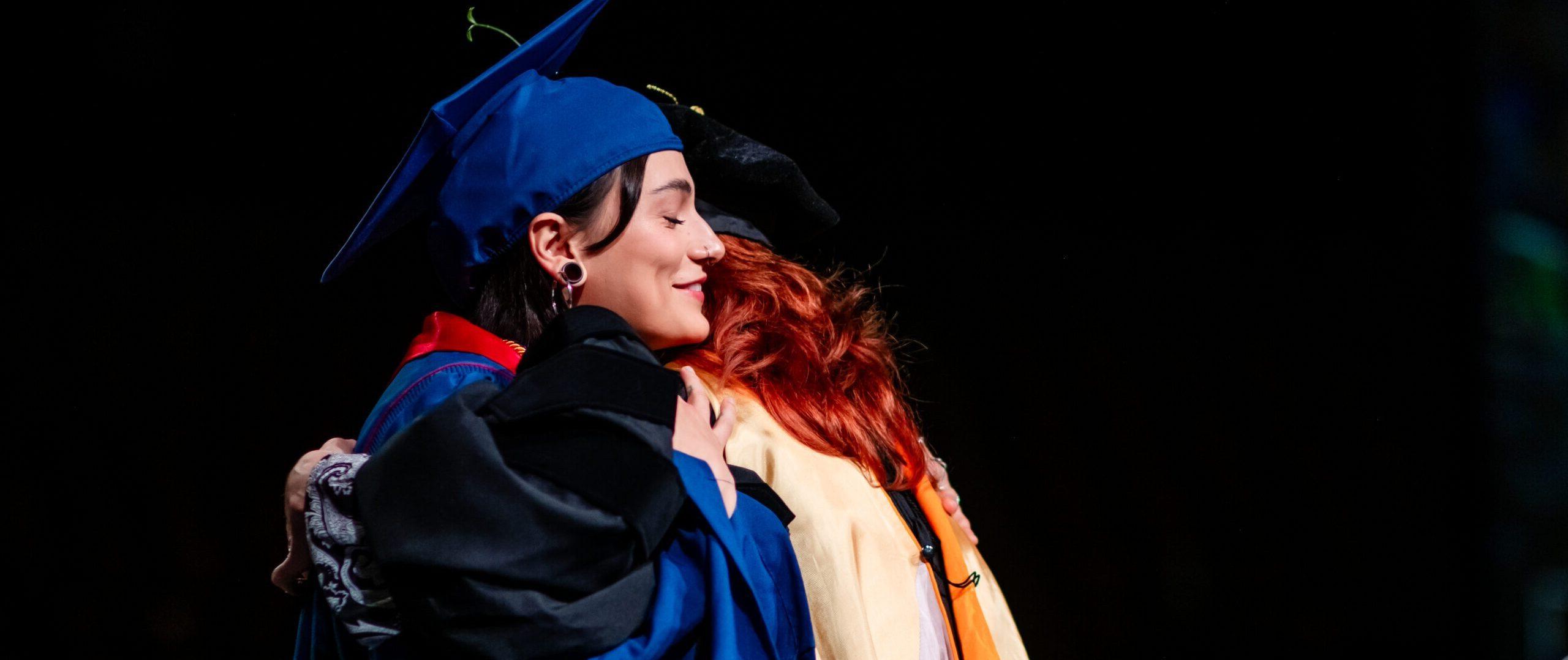 Provost's Award winner, Valeria Pernas, hugs her dean, Hope Sypulski, before giver her speech at Commencement.