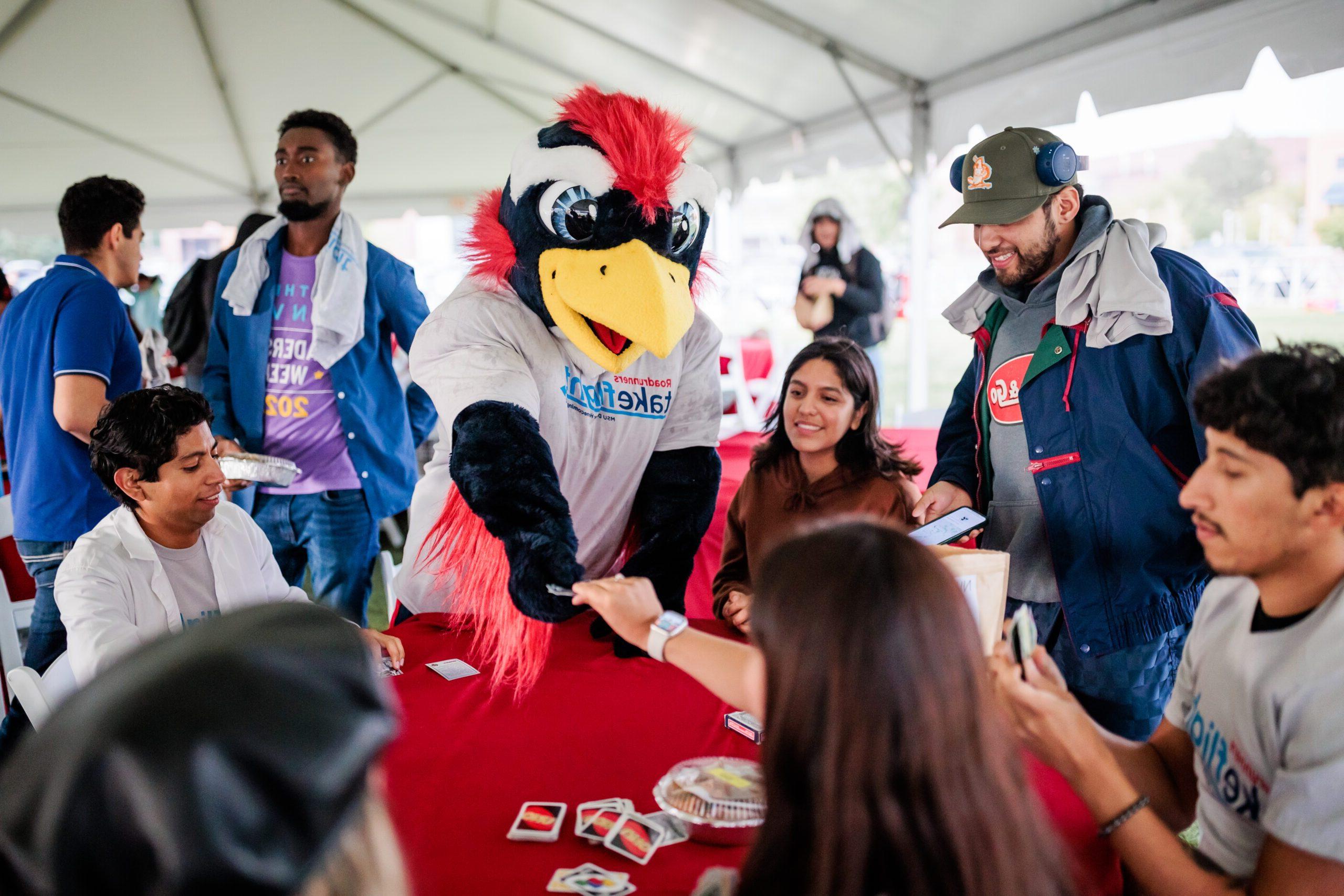 Rowdy plays Uno with a group of students