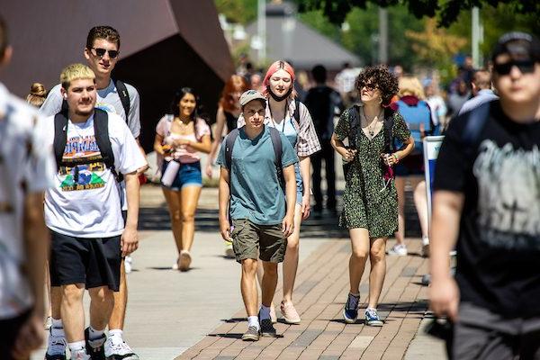 A group of students, dressed in shorts and dresses, walk the near the Tivolvi