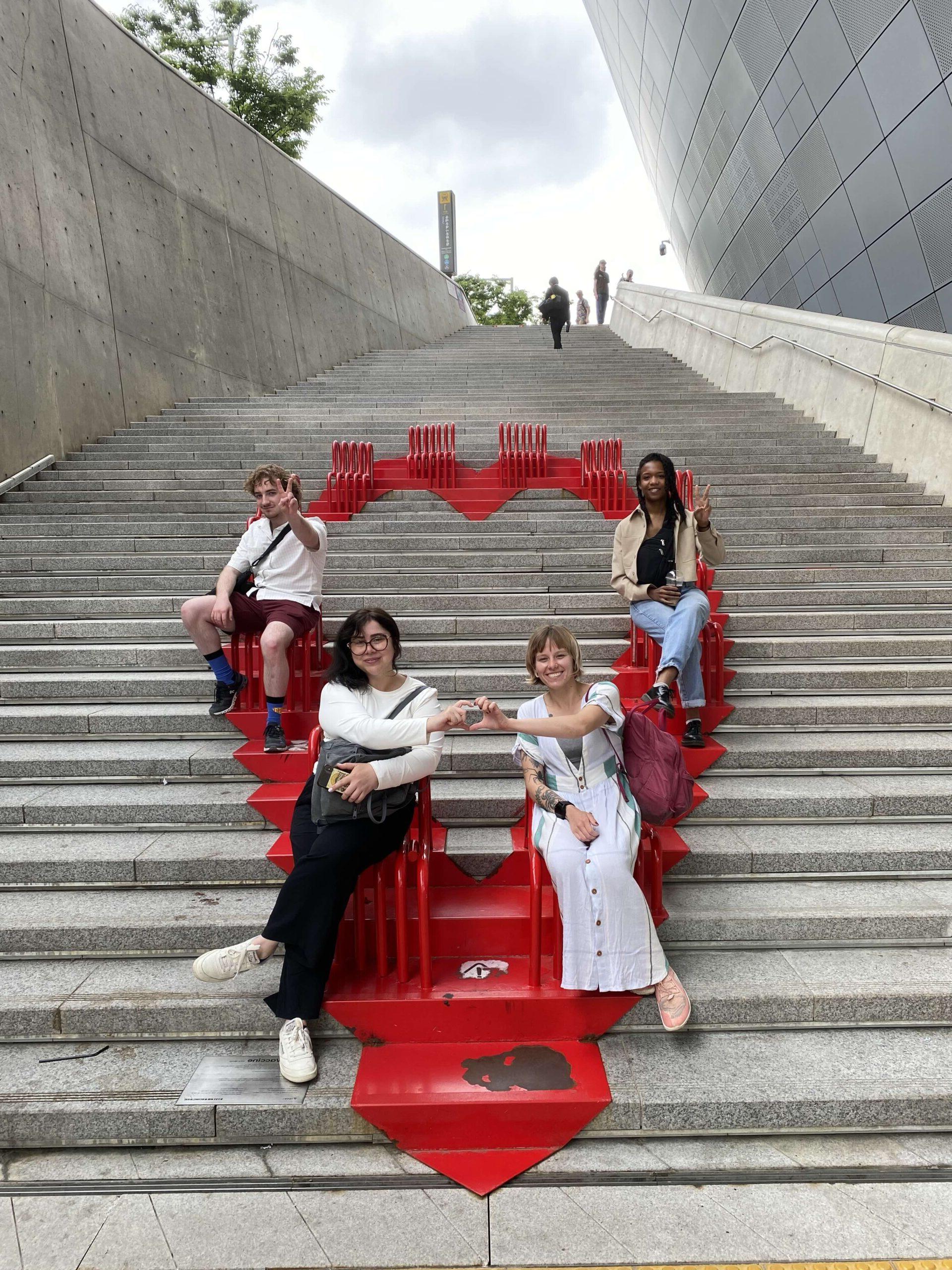 Instillation art of a read heart with students sitting on chairs, in Seoul, South Korea