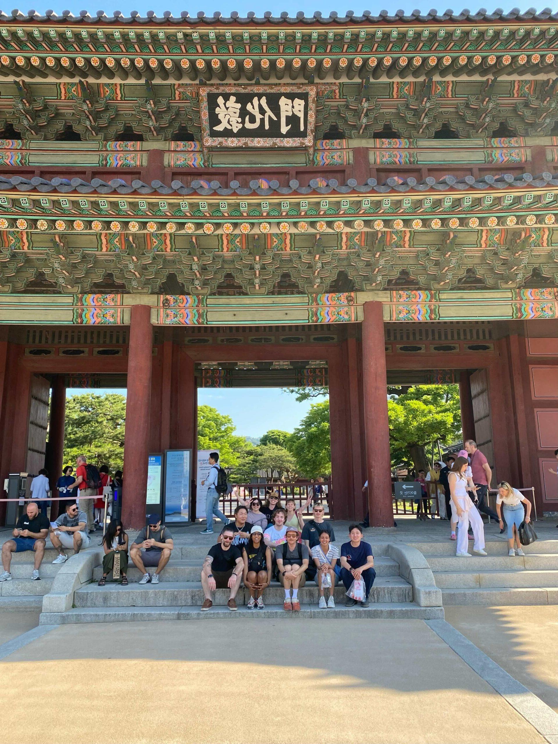 Students sitting at steps of ancient Seoul, South Korean palace