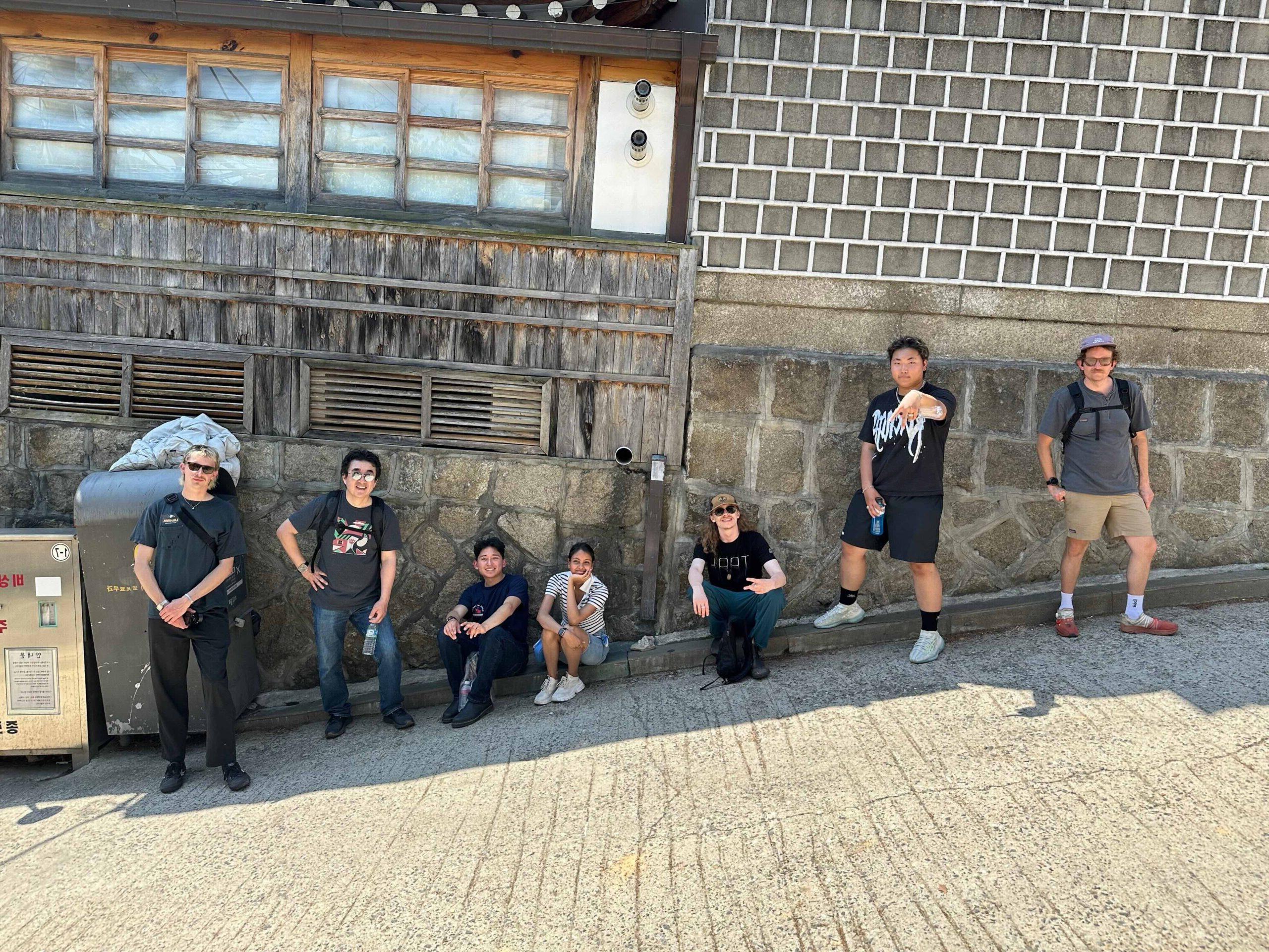 Students kneeling and sitting on cobblestone street