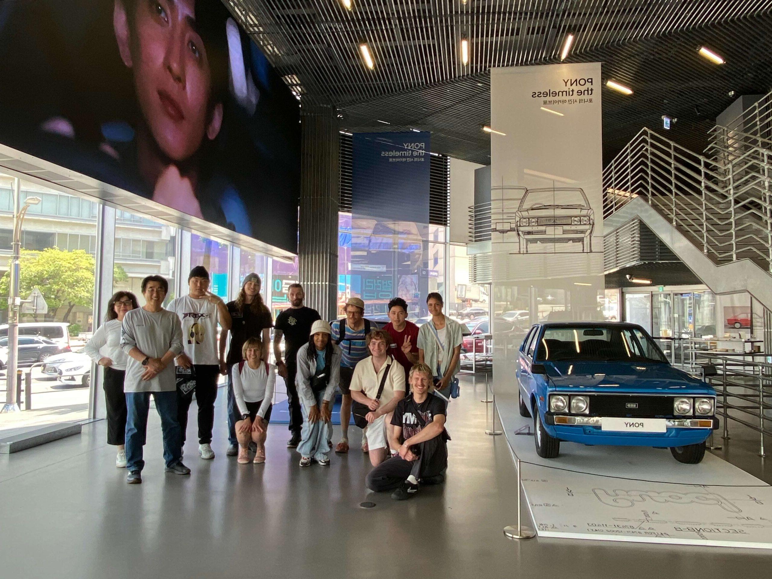 Students standing next to museum cars at the Hyundai Design Center, in Seoul, South Korea