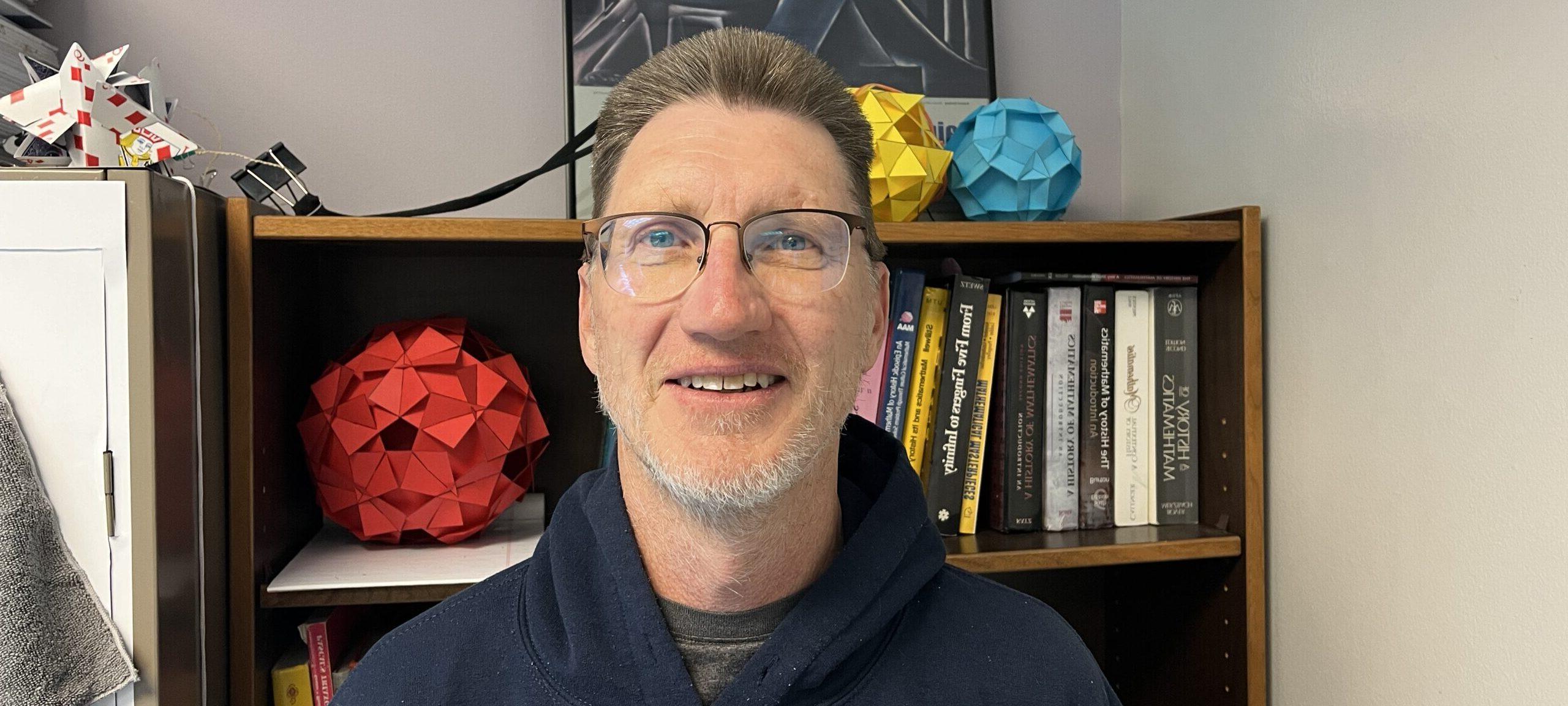 Dr. John Carter smiling in his office