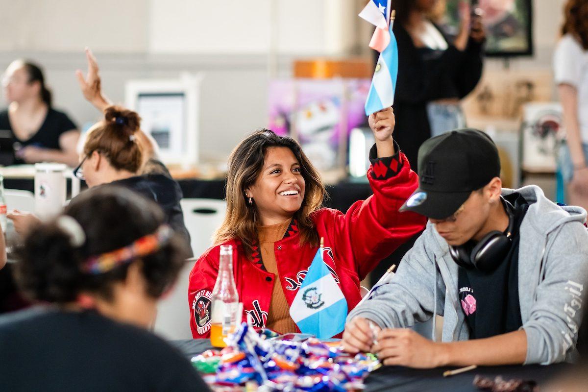 A student holding and flag and smiling