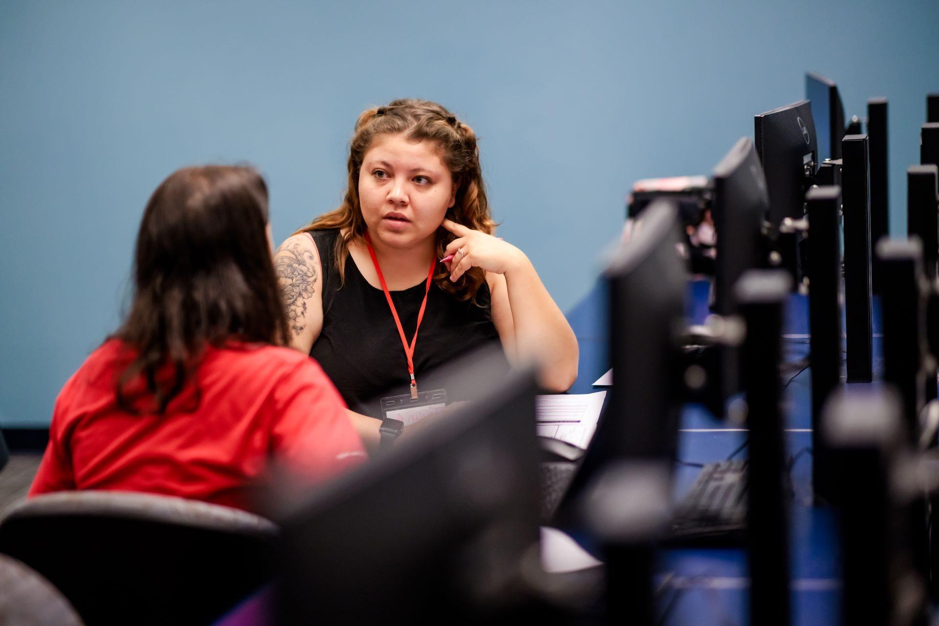 Two people talking in a computer lab