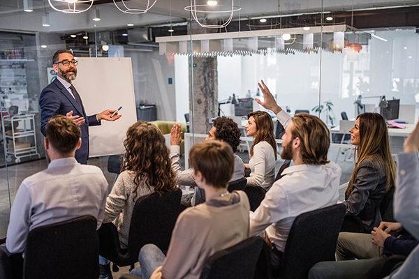 Professionals learning at a workshop led by instructor standing in front of the room